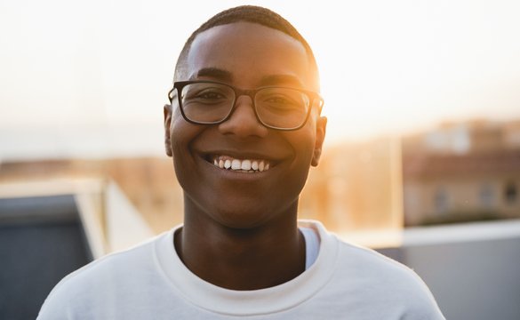 Young boy wearing glasses and reading a book.