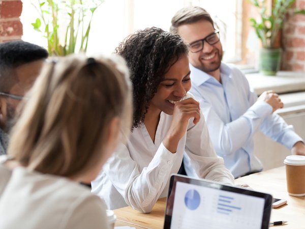 Group of young professionals talking at a conference table.