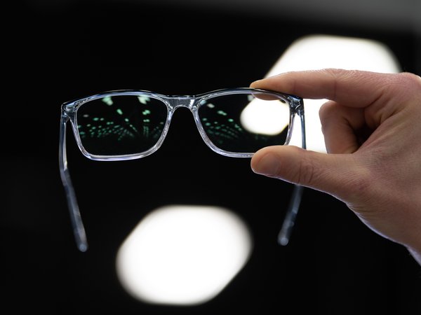 Hand holding up glasses to a light