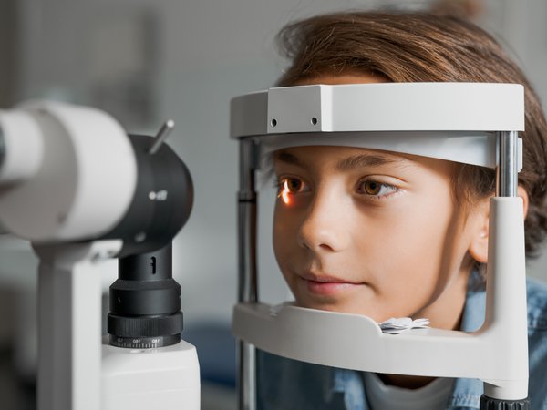 Woman using machine to look in patients eyes
