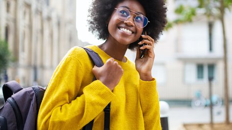 Smiling woman with glasses talking on the phone.